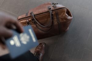 Best Handbags for Travel brown leather travel bag with passport at an airport